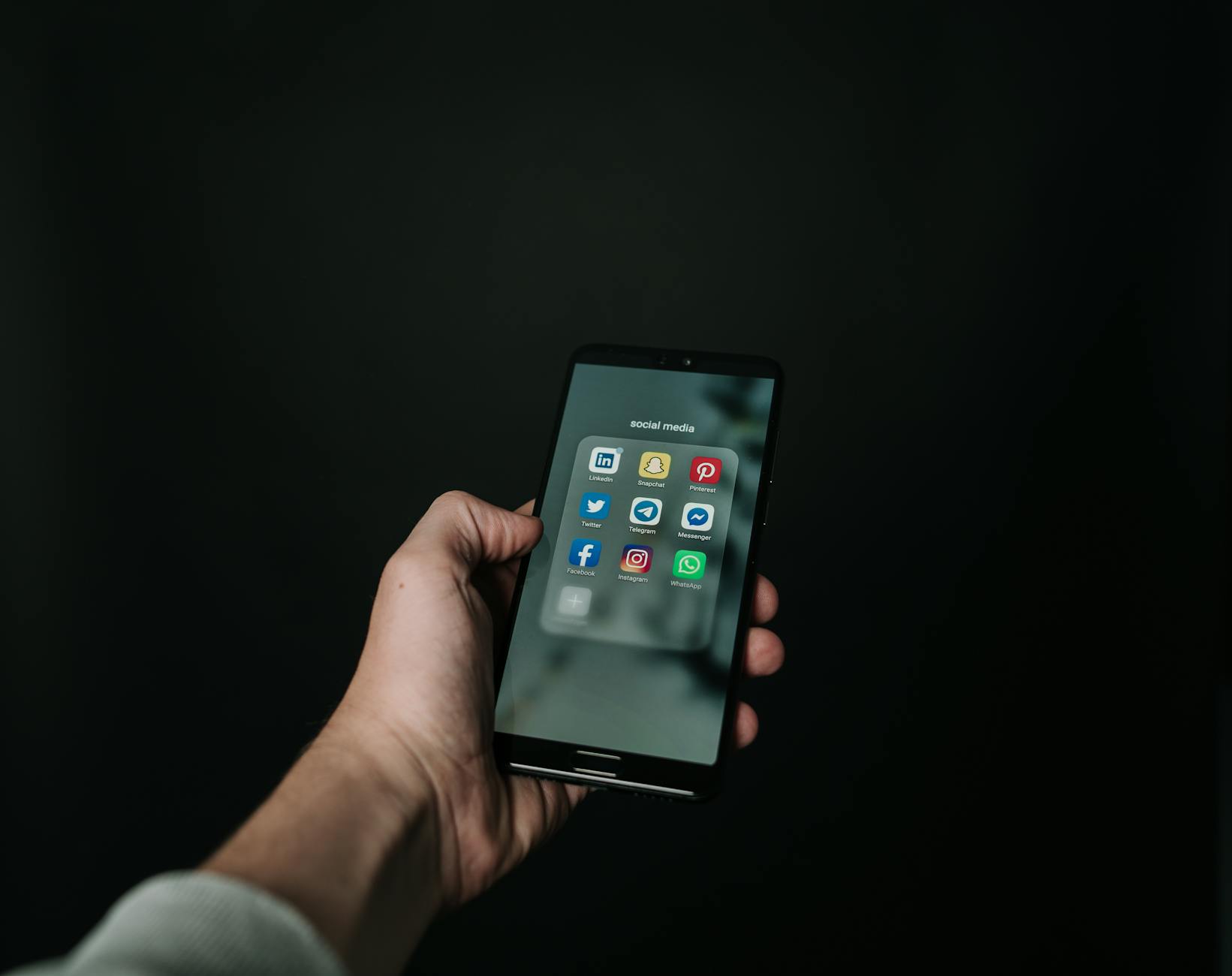 photo of hand holding a black smartphone